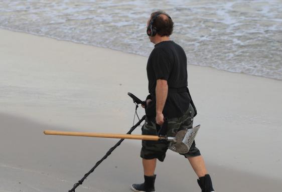 男子用金屬檢測儀檢測埋在沙子里的金屬 美國一男子用金屬檢測儀找到了50年前的鉆戒